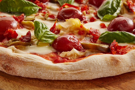 Knusprige Pizza mit Tomaten, Käse und frischen Zutaten frisch zubereitet